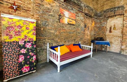 ein Zimmer mit einem Bett mit bunten Kissen darauf in der Unterkunft Hostel Casa Grande in Prado