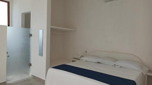 a white bed with two pillows in a bedroom at QUINTA DIAMANTE villas&hotel in Barra Vieja