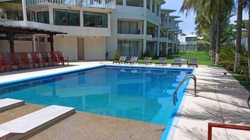 a swimming pool in front of a building at QUINTA DIAMANTE villas&hotel in Barra Vieja