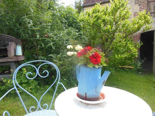 a blue vase with flowers in it sitting on a table at Chambres d'Hôtes des Grands Prés in Argentan