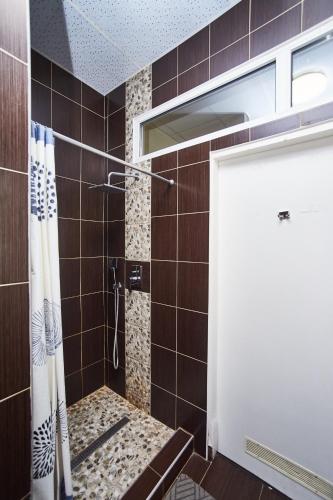 a bathroom with a shower with a glass door at Old Courtyard Hostel in Odesa