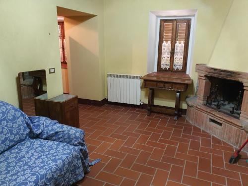 a living room with a couch and a fireplace at - Agriturismo La Piaggia - forest view apartment on the ground floor 2 guests in Vivo dʼOrcia