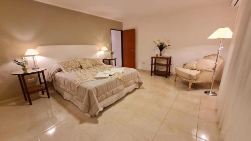 1 dormitorio con 1 cama grande y 1 silla en Nidale Suites 1 en La Rioja