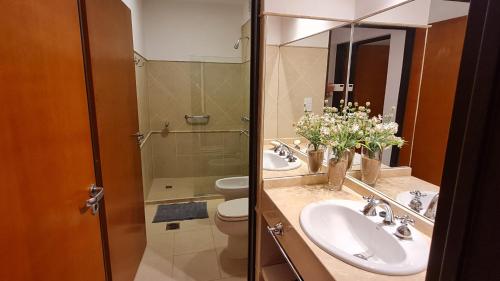 a bathroom with two sinks and a toilet and a mirror at Nidale Suites 1 in La Rioja