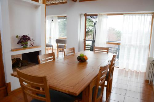een eetkamer met een houten tafel en stoelen bij Gross Guest House in Bariloche