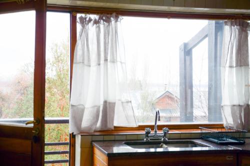 a kitchen with a sink and a large window at Gross Guest House in San Carlos de Bariloche