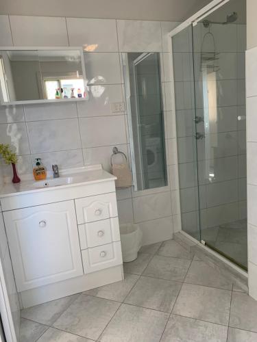 baño blanco con ducha y lavamanos en Beachside & Jetty View Apartment 7 - Sea Eagle Nest Apartment, en Streaky Bay