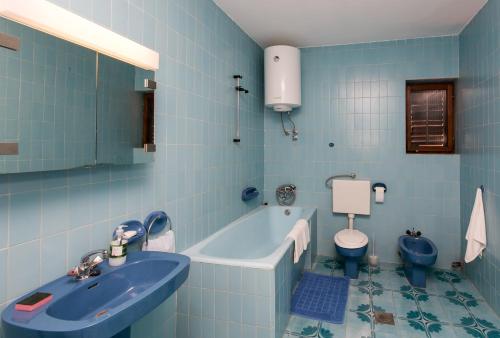 a blue bathroom with a sink and a toilet at Apartmani Kate, Plat in Mlini