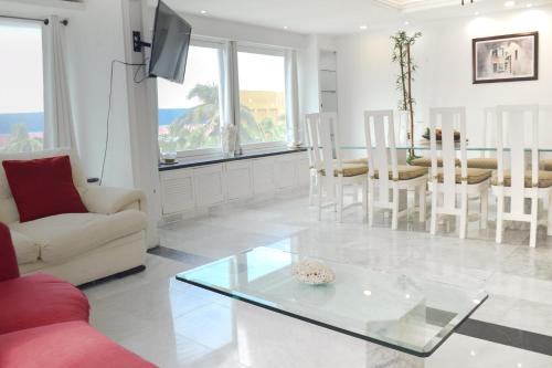 a living room with a glass table and chairs at Departamento sobre la playa Cancun in Cancún