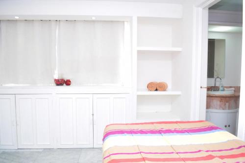 a white room with a bed and a window at Departamento sobre la playa Cancun in Cancún