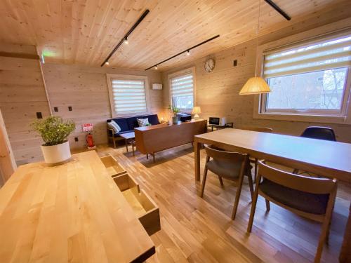 a room with a table and chairs and a dining room at BAAN HAKUBA in Hakuba