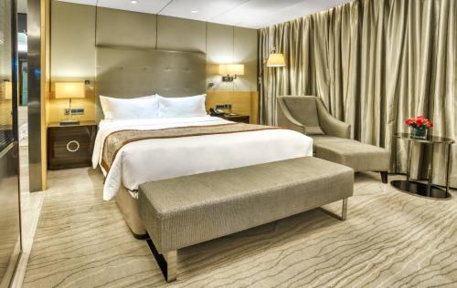 a hotel room with a bed and a chair at Enlux Hotel in Jinan