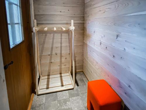 a wooden room with a ladder and an orange stool at BAAN HAKUBA in Hakuba