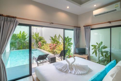 a bedroom with a view of a pool and a bed at Layantara Villas in Layan Beach