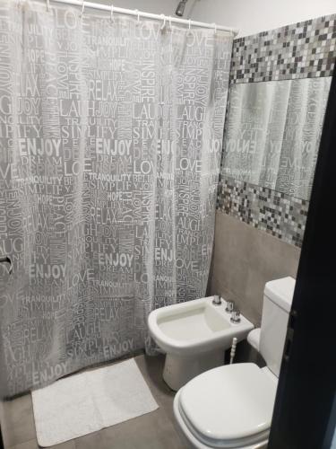 a bathroom with a toilet and a shower curtain at Costanera.VM in Villa María