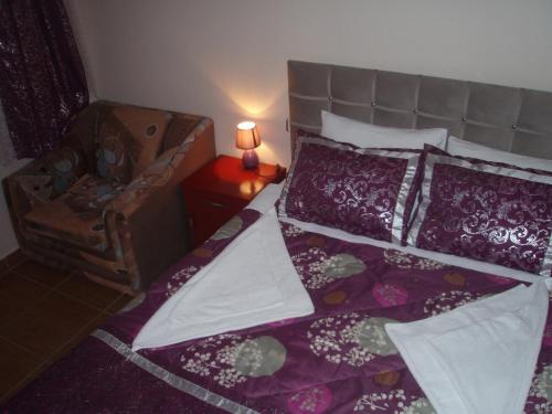 a bedroom with a bed with purple sheets and a chair at Hotel Pamukkale in Pamukkale