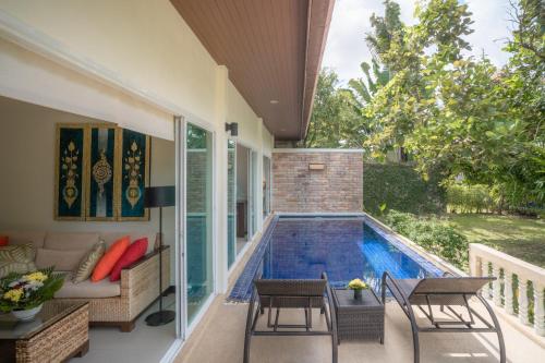 a patio with a swimming pool next to a house at Layantara Villas in Layan Beach