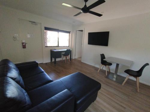 a living room with a couch and a table at Cascade Motel In Townsville in Townsville