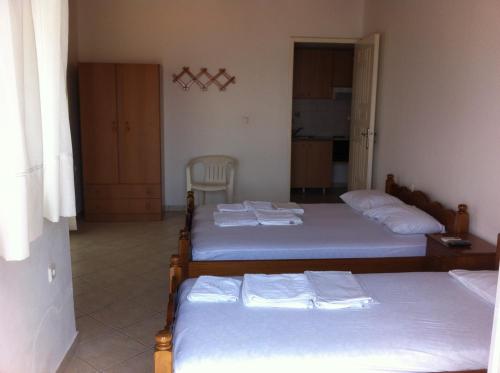 a room with three beds in it with a kitchen at Georgia in Nikiana