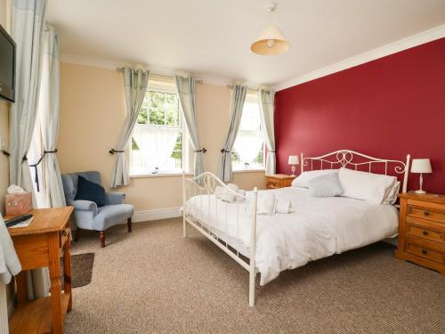 a bedroom with a white bed and a red wall at Woodhill in Bentley