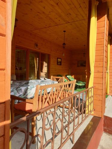 a porch of a wooden house with a table and chairs at Zielony Domek - Tleń Bory Tucholskie in Tleń