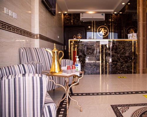 a room with two chairs and a table with a vase at زائر الفخامه للشقق المخدومه in Tabuk