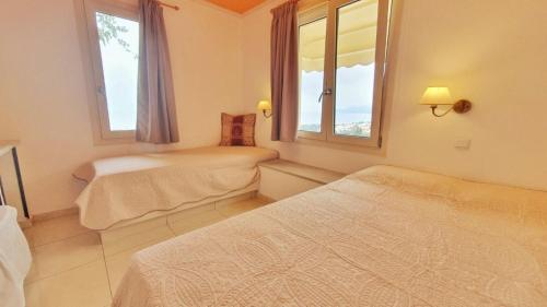 een slaapkamer met 2 bedden en 2 ramen bij One Private Studio full view in Chersonissos