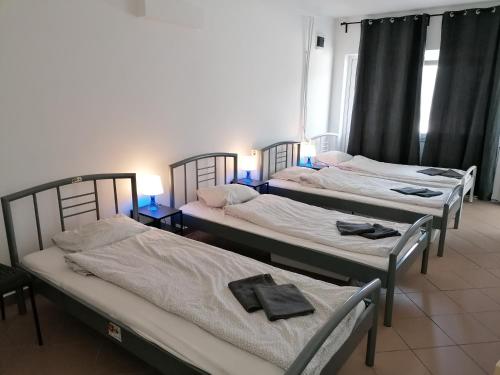 Tres camas en una habitación con toallas. en Omega Szigetszentmiklós, en Szigetszentmiklós