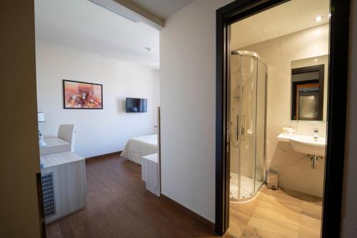 a bathroom with a shower and a sink and a bed at Hotel della Signoria in Florence
