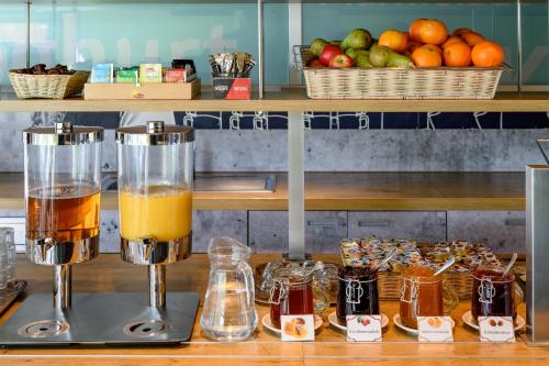 a counter with two glasses of juice and fruit at ibis budget Zurich City West in Zürich