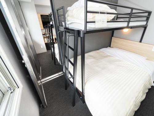 a room with two bunk beds and a bed at Super Hotel Mitazono Sendai Airport in Natori
