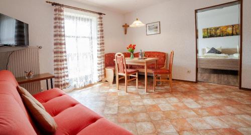 a living room with a table and a couch at Ferienhof Guglhupf in Sankt Oswald