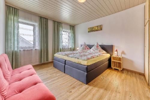 a bedroom with a bed and a couch in a room at Ferienhof Guglhupf in Sankt Oswald