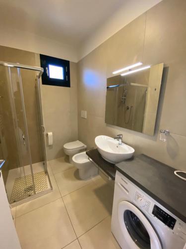 uma casa de banho com uma máquina de lavar roupa e um lavatório em APPARTAMENTO NUOVO CENTRALISSIMO 150 MT DAL MARE em Lido di Jesolo