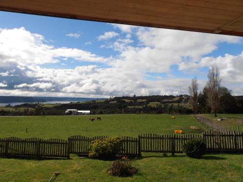 a field with a fence and horses in a field at Agroturismo Coñico in Quilquico