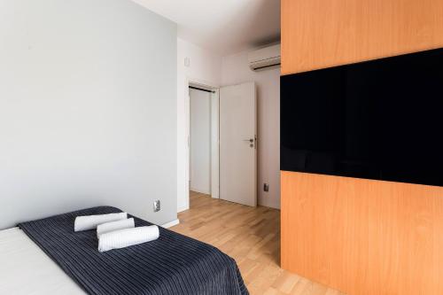 a bedroom with a bed with a large television on the wall at DD Apartments in Cluj-Napoca