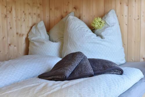 a bed with two pillows on top of it at Islandpferdehof Seelengrübchen - Ferien im Bauwagen in Glött