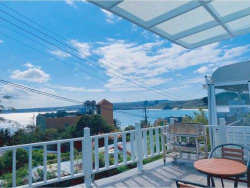 a balcony with a table and chairs and a view of the water at Sky Grass in Nanwan