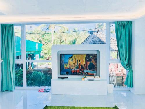 a living room with a tv and a large window at Sky Grass in Nanwan