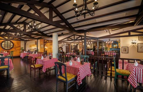 a dining room with red and white striped tables and chairs at Millennium Airport Hotel Dubai in Dubai
