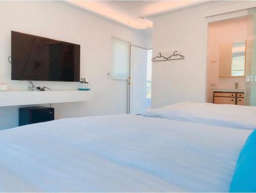 a white bedroom with a white bed and a sink at Sky Grass in Nanwan