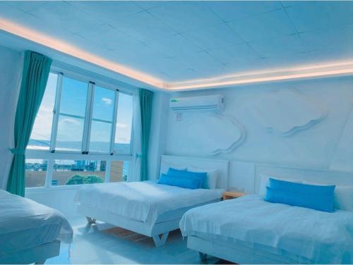 a bedroom with two beds and a large window at Sky Grass in Nanwan