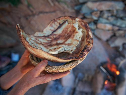 a person holding a piece of bread in their hand at Kasbah Africa - High Atlas Dark Sky & Nature Lodge in Ouirgane