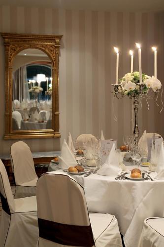 a dining room with a white table with chairs and candles at Rodos Park in Rhodes Town