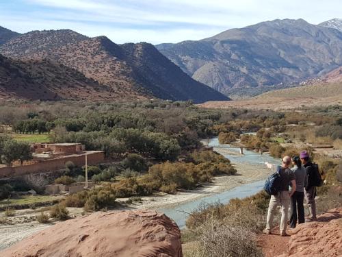 a group of people standing on a rock overlooking a river at Kasbah Africa - High Atlas Dark Sky & Nature Lodge in Ouirgane