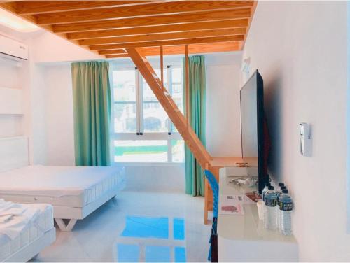 a bedroom with a bed and a tv in a room at Sky Grass in Nanwan