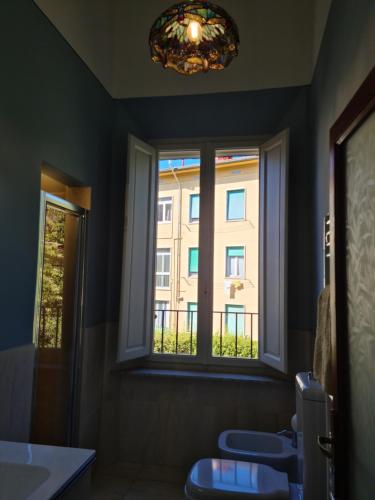 baño con 2 aseos y ventana en Appartamento Angela, en Pisa