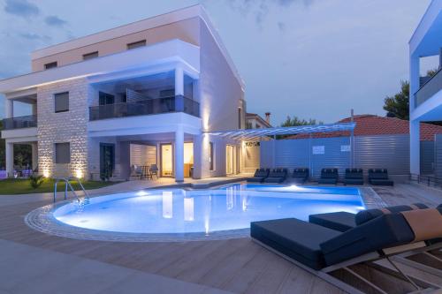 a large swimming pool in front of a house at Leon Villas in Nikiti