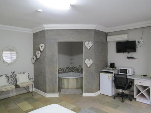 een kamer met een keuken met een bad en een magnetron bij Olden Rose Place in Lephalale