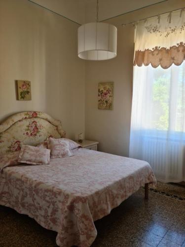 un dormitorio con una cama y una ventana en Appartamento Angela, en Pisa